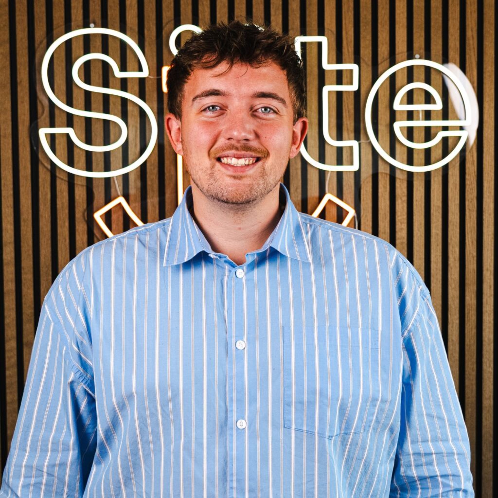 Mand i blå skjorte foran skilt