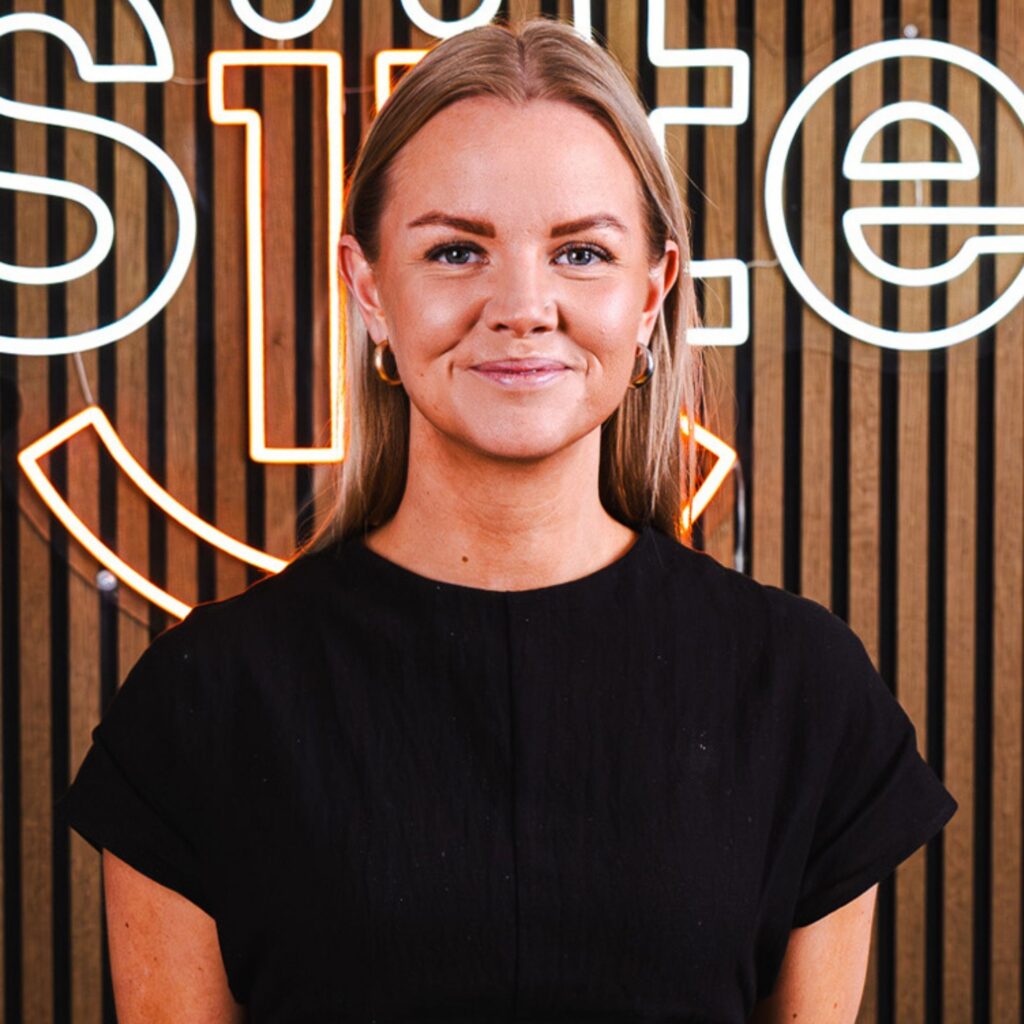 Kvinde foran neonskilt