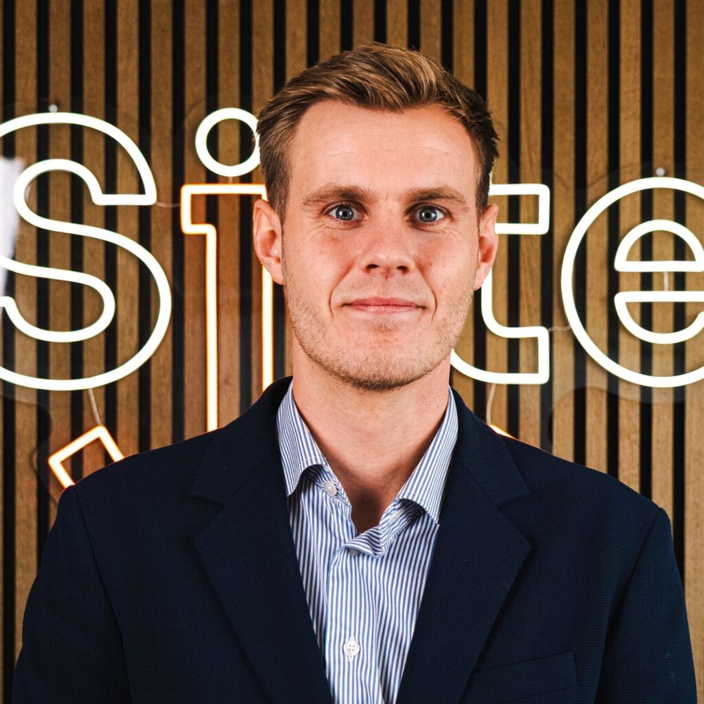 Mand i jakkesæt foran kontorvæg