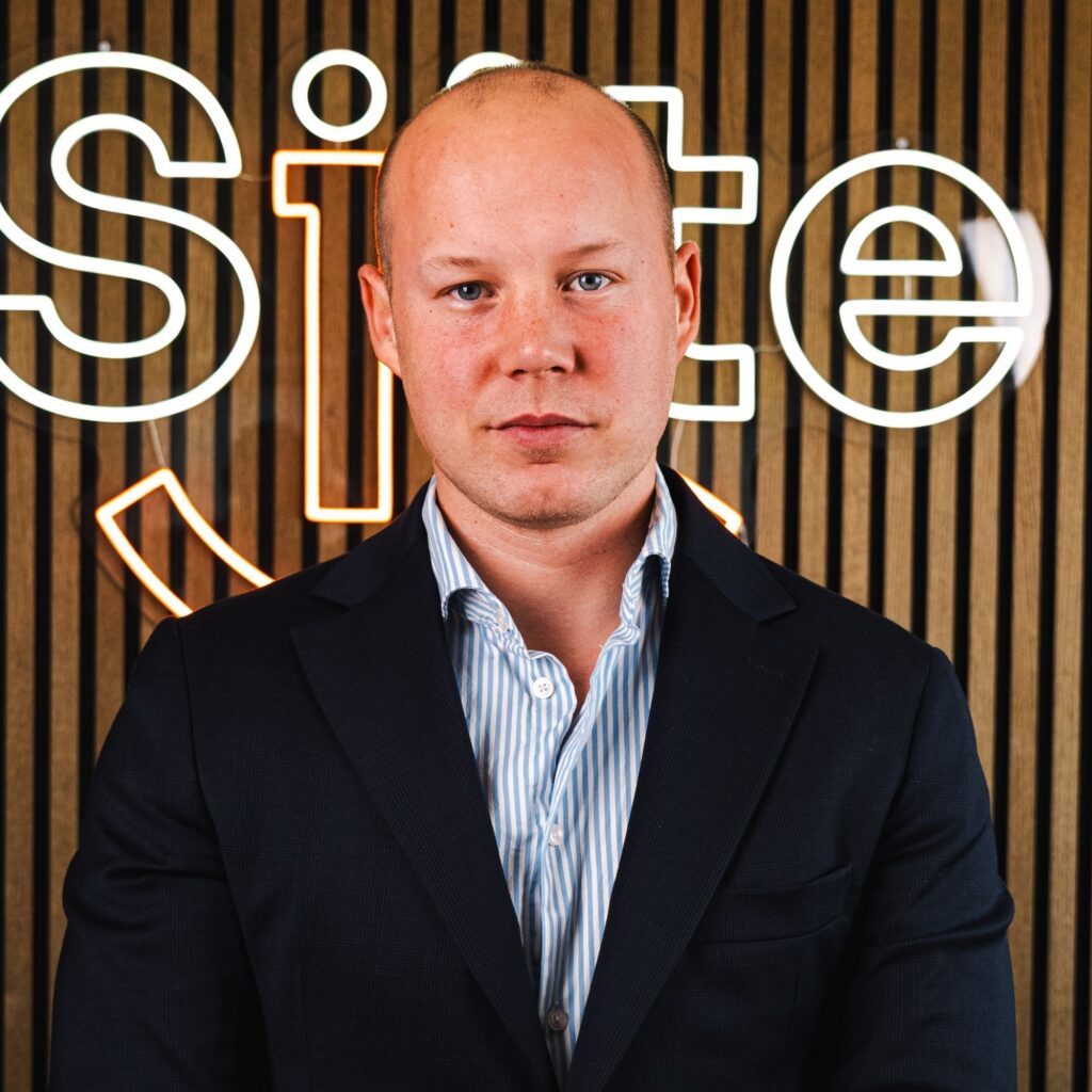 Mand i jakkesæt foran neon-skilt