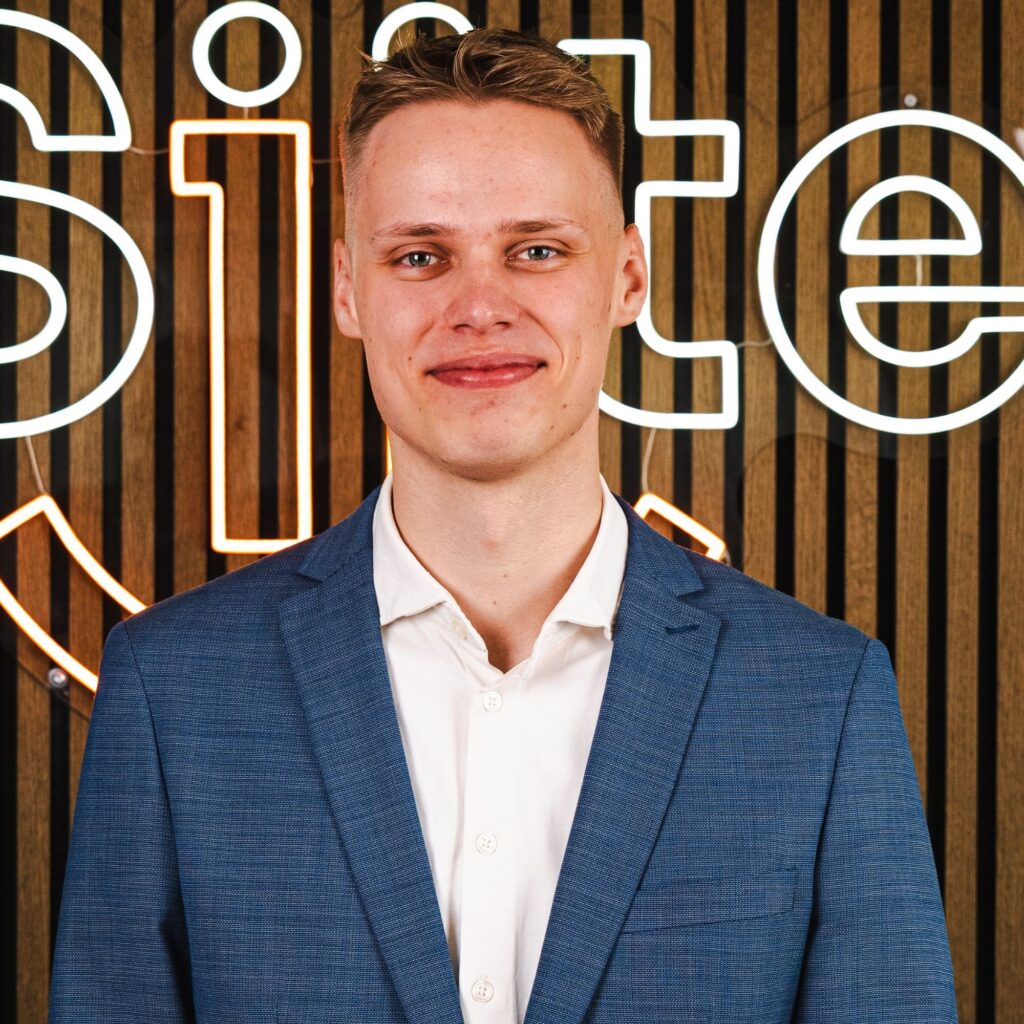 Mand i jakkesæt foran neonskilt