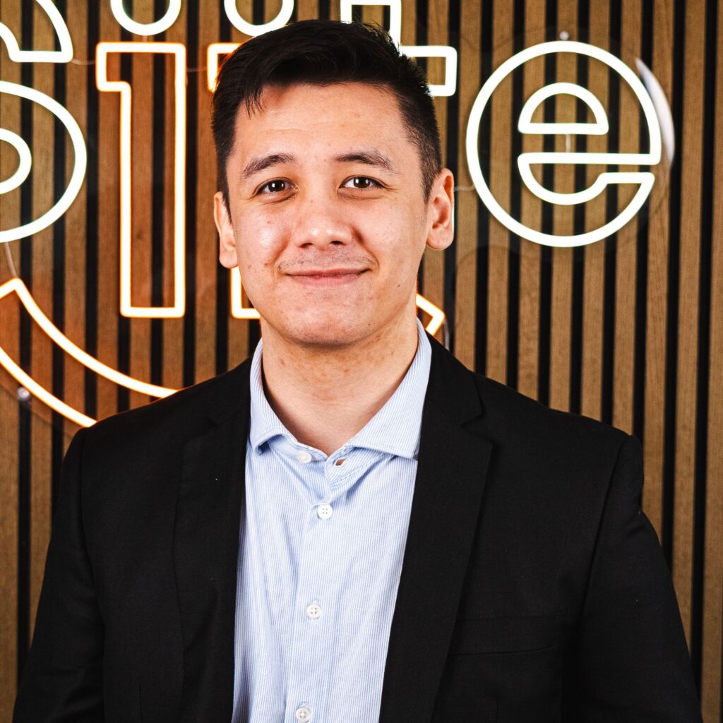 Mand i jakkesæt foran neonskilt