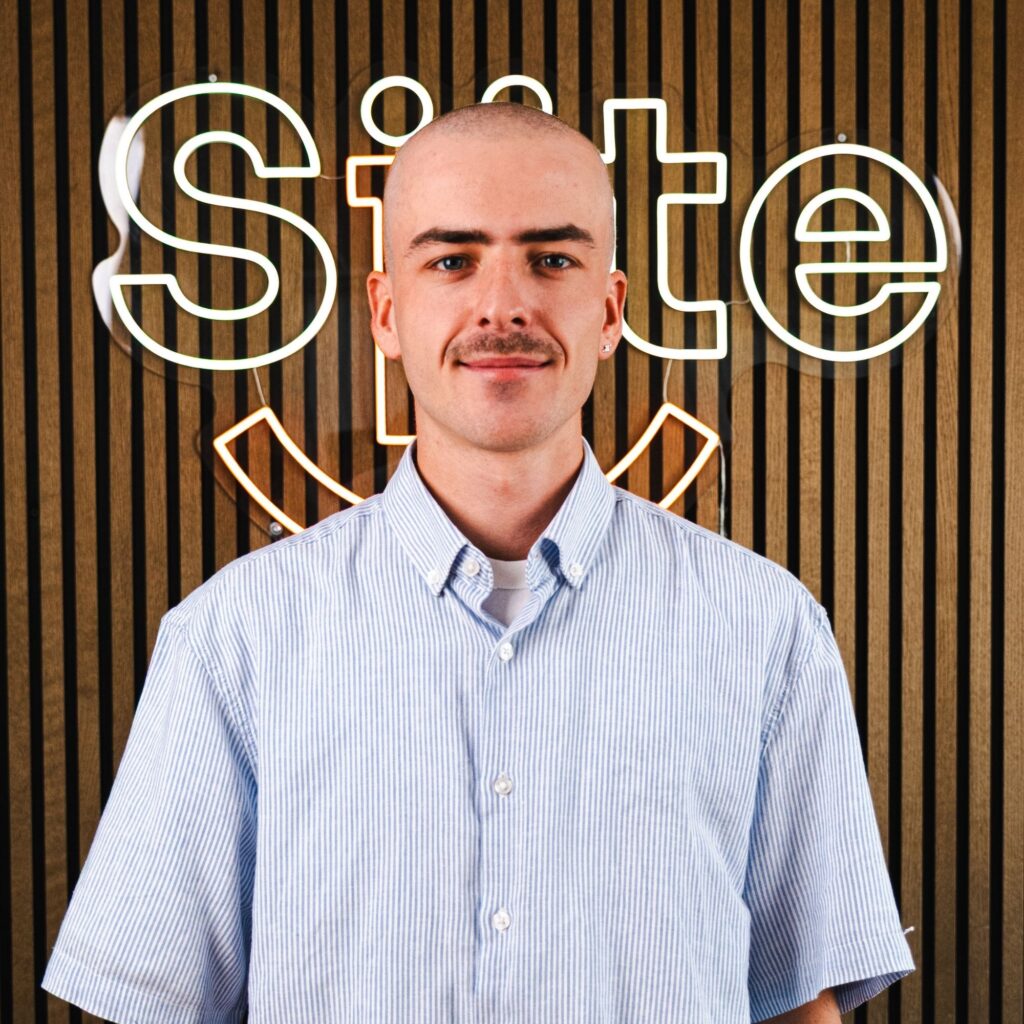 Mand foran trævæg med lysende skilt