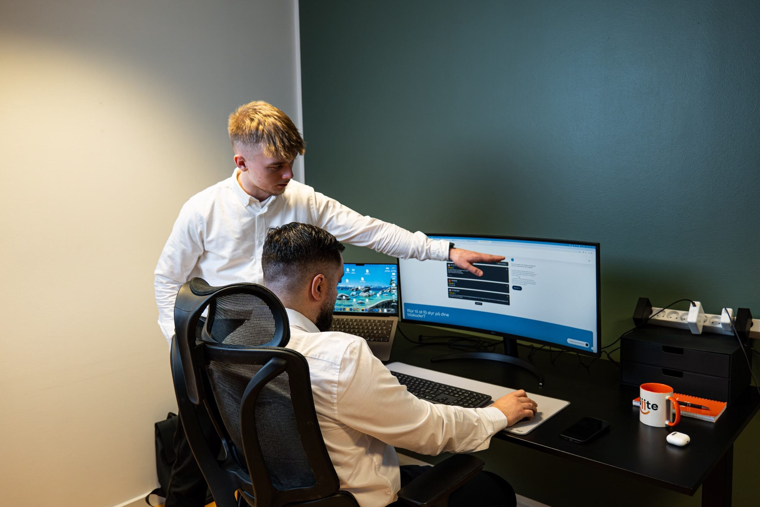 To mænd arbejder ved computer på kontor